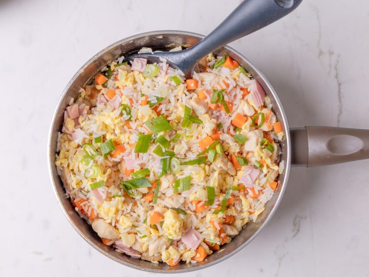 Arroz cozido adicionado a frigideira.