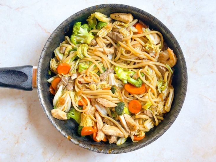 Macarrão, carnes e acelga adicionada na panela.