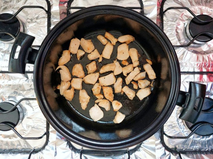 Panela com pedaços de frango sendo fritos.