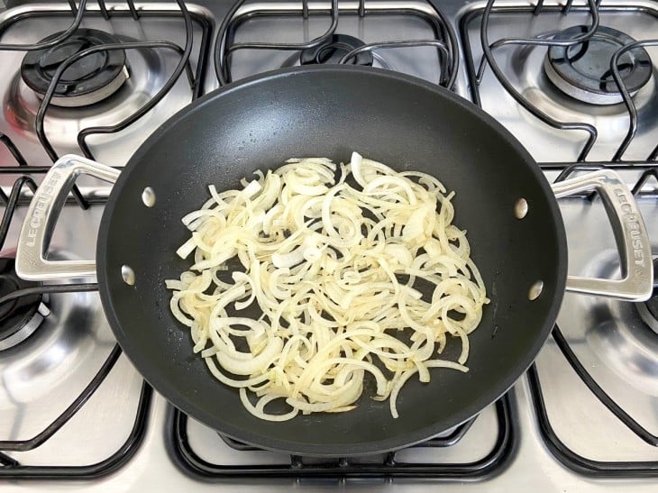 Uma frigideira com cebola refogada.